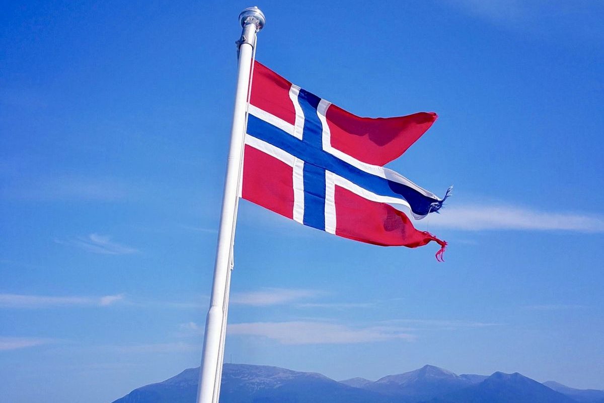 Norsk flagg akter på båt til sjøs